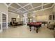 Elegant living room with coffered ceilings, a billiard table, and a dining area with a chandelier at 30314 Fairway Dr, Wesley Chapel, FL 33543