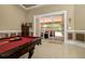 Living room with a billiard table and a view of an outdoor lounge area through sliding glass doors at 30314 Fairway Dr, Wesley Chapel, FL 33543