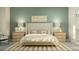 Bright bedroom with a neutral color palette, a large bed with a padded headboard, and matching nightstands with lamps at 31556 Cardinal Yard Dr, San Antonio, FL 33576