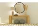Elegant entryway features a wooden console table, decorative lamp, and round mirror, creating a stylish and welcoming space at 31556 Cardinal Yard Dr, San Antonio, FL 33576