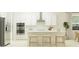 Modern kitchen with white cabinets, stainless steel appliances, and an island with bar stools, creating a clean, efficient space at 31556 Cardinal Yard Dr, San Antonio, FL 33576