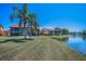 Expansive green backyard with palm trees, waterfront, and serene condo complex view at 3847 Lighthouse Way # 3847, New Port Richey, FL 34652