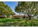 Expansive backyard with mature trees, a bench and lake views at 3847 Lighthouse Way # 3847, New Port Richey, FL 34652
