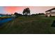 Beautiful backyard with a lush green lawn, a tranquil canal and open skies at sunset at 3847 Lighthouse Way # 3847, New Port Richey, FL 34652