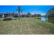 Spacious backyard with lush lawn leading to waterfront and views of condominium complex at 3847 Lighthouse Way # 3847, New Port Richey, FL 34652