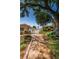 Inviting landscaped pathway leads to a gated community entrance, surrounded by mature trees at 3847 Lighthouse Way # 3847, New Port Richey, FL 34652