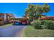 Exterior shot showcasing covered parking, mature trees, and well-manicured landscaping at 3847 Lighthouse Way # 3847, New Port Richey, FL 34652