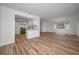 Open-concept living room features light wood flooring, an abundance of natural light, and adjacent updated kitchen at 3847 Lighthouse Way # 3847, New Port Richey, FL 34652