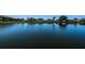 Relaxing pond view surrounded by lush landscaping, reflecting the clear blue sky and nearby condo community at 3847 Lighthouse Way # 3847, New Port Richey, FL 34652