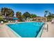 Large community pool with ample seating, umbrellas, and a tranquil atmosphere at 3847 Lighthouse Way # 3847, New Port Richey, FL 34652
