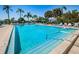 Inviting swimming pool, surrounded by lounge chairs, umbrellas, and tropical palm trees at 3847 Lighthouse Way # 3847, New Port Richey, FL 34652