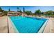 Community pool with clear blue water, shaded lounge chairs, and lush landscaping at 3847 Lighthouse Way # 3847, New Port Richey, FL 34652