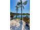 Picturesque waterfront view with a serene lake, tropical plants, and a paved patio at 3847 Lighthouse Way # 3847, New Port Richey, FL 34652