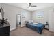 Bedroom with blue blanket, two windows, ceiling fan, and side table at 4715 W Montgomery Ave, Tampa, FL 33616