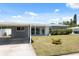 This single-story home has a covered carport and a well-manicured lawn with a small yard plant at 4715 W Montgomery Ave, Tampa, FL 33616