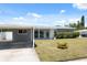 This single-story home has a covered carport and a well-manicured lawn with a small yard plant at 4715 W Montgomery Ave, Tampa, FL 33616