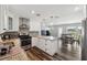 Open kitchen featuring wood floors, granite countertops, stainless steel appliances, and ample counter space at 4715 W Montgomery Ave, Tampa, FL 33616