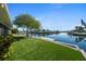 Lush backyard features a grassy lawn, mature trees, a private dock, and stunning views of the canal at 4968 Southshore Dr, New Port Richey, FL 34652