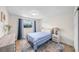 Comfortable bedroom with a blue striped bedspread, wood floors, and natural light from the window at 4968 Southshore Dr, New Port Richey, FL 34652