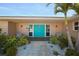 Beautiful entrance with blue double doors, lush landscaping, and accent lighting at 4968 Southshore Dr, New Port Richey, FL 34652