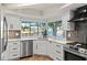 This kitchen boasts stainless steel appliances, white cabinetry, and a stunning water view from the window over the sink at 4968 Southshore Dr, New Port Richey, FL 34652