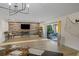 Open living space with a decorative accent wall, modern lighting, and sliding door access to the outdoor patio at 4968 Southshore Dr, New Port Richey, FL 34652