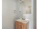 Compact half-bathroom featuring a wood vanity, sink, and neutral color palette for a clean aesthetic at 6343 Osprey Lake Circle, Riverview, FL 33578