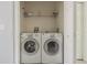 Convenient laundry area featuring a side-by-side washer and dryer, with shelving for storage solutions at 6343 Osprey Lake Circle, Riverview, FL 33578