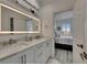 Bathroom featuring double sinks, marble counters and nautical-themed decor and a bedroom view at 718 Manns Harbor Dr, Apollo Beach, FL 33572