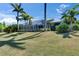 Beautiful single-story home boasts a screened lanai, well-maintained lawn, and lush tropical landscaping with palm trees at 718 Manns Harbor Dr, Apollo Beach, FL 33572