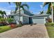 Beautiful two-story coastal home featuring a brick driveway and a spacious three-car garage at 718 Manns Harbor Dr, Apollo Beach, FL 33572