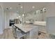 Modern kitchen with waterfall island, bar stool seating and stainless steel appliances at 718 Manns Harbor Dr, Apollo Beach, FL 33572