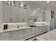 Detail of the sleek, white kitchen with modern cabinets, countertop lighting, and matching backsplash at 718 Manns Harbor Dr, Apollo Beach, FL 33572