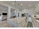 Open kitchen and living area with an island, stainless steel appliances, and modern finishes at 718 Manns Harbor Dr, Apollo Beach, FL 33572