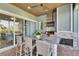 Outdoor kitchen with stone counters, seating, stainless steel grill, and attractive fireplace at 718 Manns Harbor Dr, Apollo Beach, FL 33572