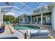 Beautiful pool area with screened enclosure, comfortable lounge seating, and lush landscaping at 718 Manns Harbor Dr, Apollo Beach, FL 33572
