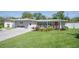 Well-maintained home boasts lush front yard with mature trees, manicured landscaping, a covered porch, and charming curb appeal at 7301 2Nd S Ave, St Petersburg, FL 33707