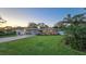 Charming single-story home with stone facade, manicured lawn, and colorful flower beds, complemented by a vibrant red front door at 7301 2Nd S Ave, St Petersburg, FL 33707