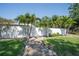 Front yard view with palm trees, a stone walkway, and lush green lawn at 7301 2Nd S Ave, St Petersburg, FL 33707