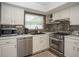 Bright kitchen featuring white cabinetry, stainless steel appliances, stone countertops, and hardwood floors at 7301 2Nd S Ave, St Petersburg, FL 33707