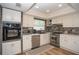 Bright kitchen featuring white cabinetry, stainless steel appliances, stone countertops, and hardwood floors at 7301 2Nd S Ave, St Petersburg, FL 33707