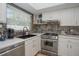 This updated kitchen features stone countertops, stainless appliances, a sink, and shaker style cabinetry at 7301 2Nd S Ave, St Petersburg, FL 33707