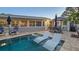 Backyard pool with in-pool lounges and outdoor dining area with an umbrella at 7301 2Nd S Ave, St Petersburg, FL 33707
