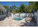 Swimming pool surrounded by lush trees, lounge furniture, and a spa with crystal blue water at 7301 2Nd S Ave, St Petersburg, FL 33707