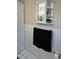 A minimalist bathroom showing a dark towel hanging next to a decorative wall cabinet at 7601 Como Dr, New Port Richey, FL 34655