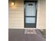 Front door with a screen door, welcome mat, and an outdoor light fixture at 7601 Como Dr, New Port Richey, FL 34655