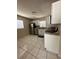Well-lit kitchen featuring stainless steel appliances, white cabinetry, and tile flooring at 7601 Como Dr, New Port Richey, FL 34655