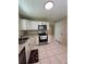 Bright kitchen featuring stainless steel appliances, white cabinets, and tile flooring at 7601 Como Dr, New Port Richey, FL 34655