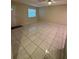 Large, open living area with tile floors, neutral paint, and natural light from a window at 7601 Como Dr, New Port Richey, FL 34655