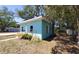 Side view of a light blue single-story home with landscaping, windows, and walkway at 769 53Rd N Ter, St Petersburg, FL 33703